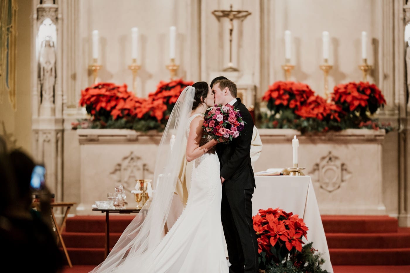 bride and groom first kiss at black tie winter wedding