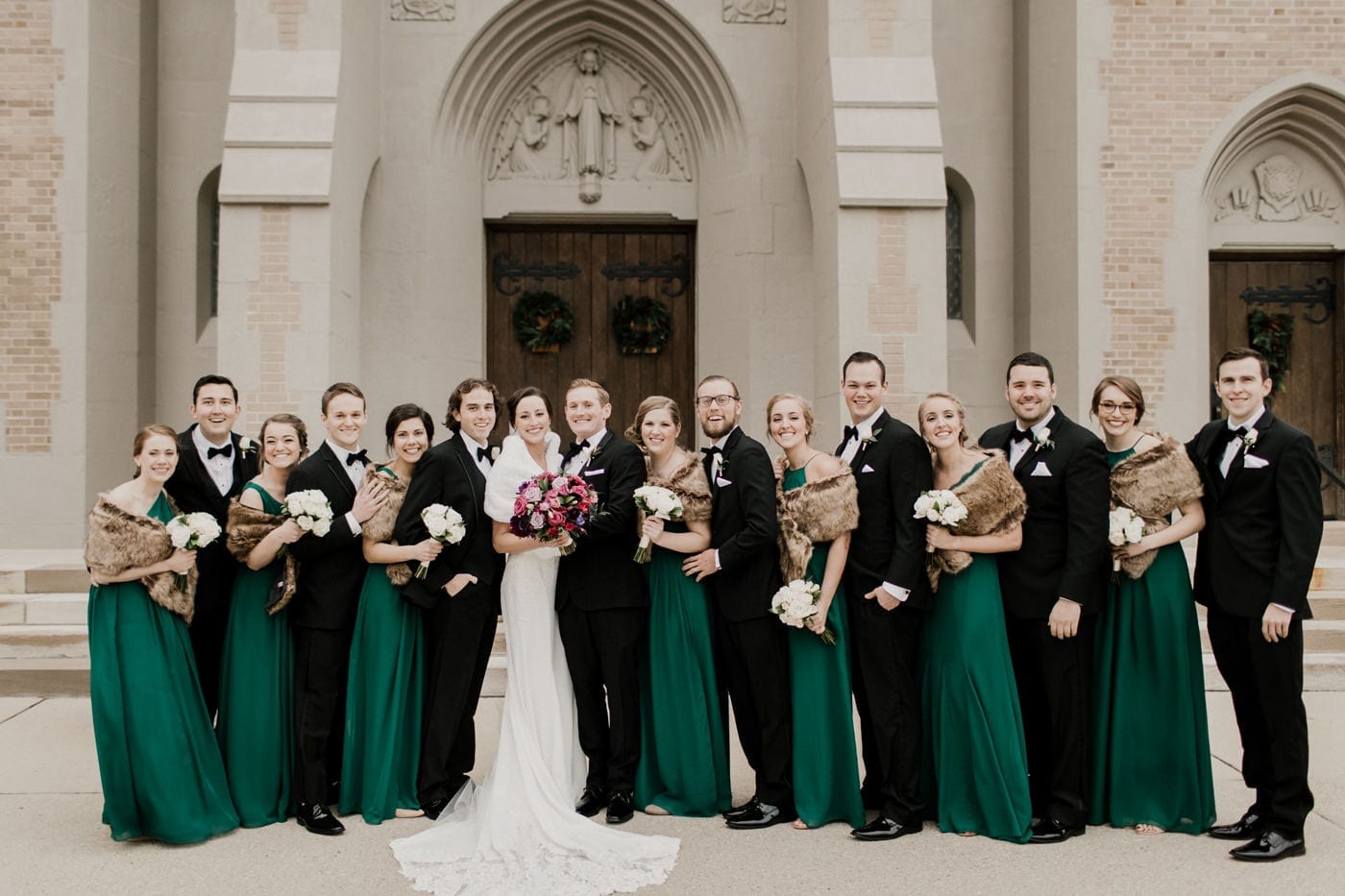 bride groom and bridal party in front of church at black tie winter wedding