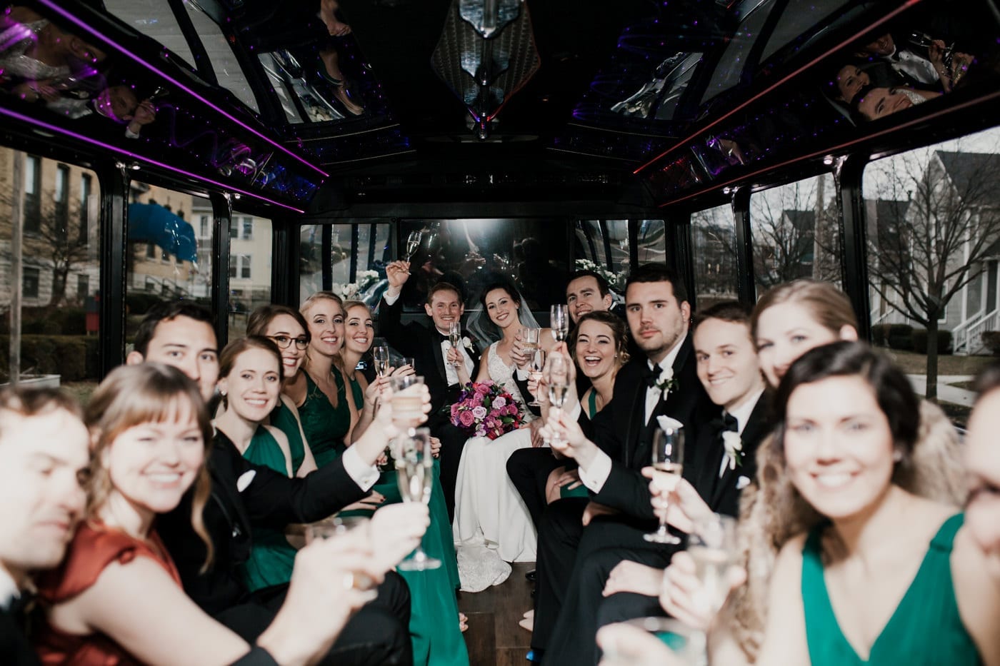 bride groom and bridal party on party buss at black tie winter wedding
