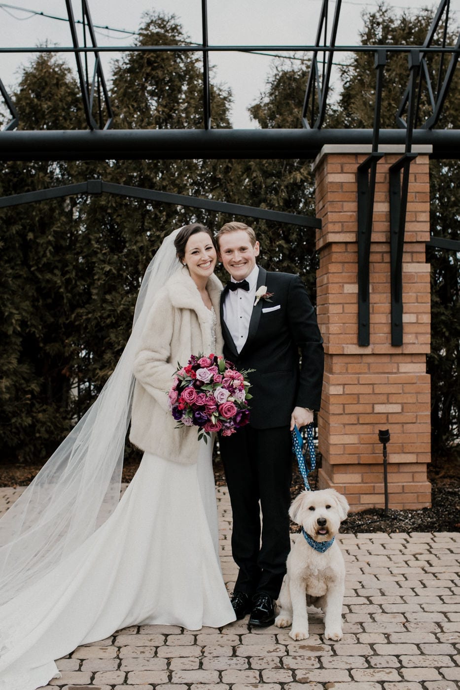 bride and groom with dog at black tie winter wedding