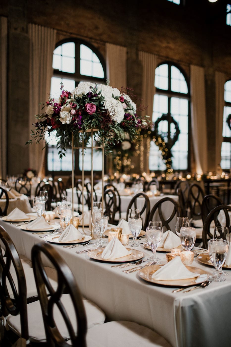 reception tables with floral arrangements at black tie winter wedding