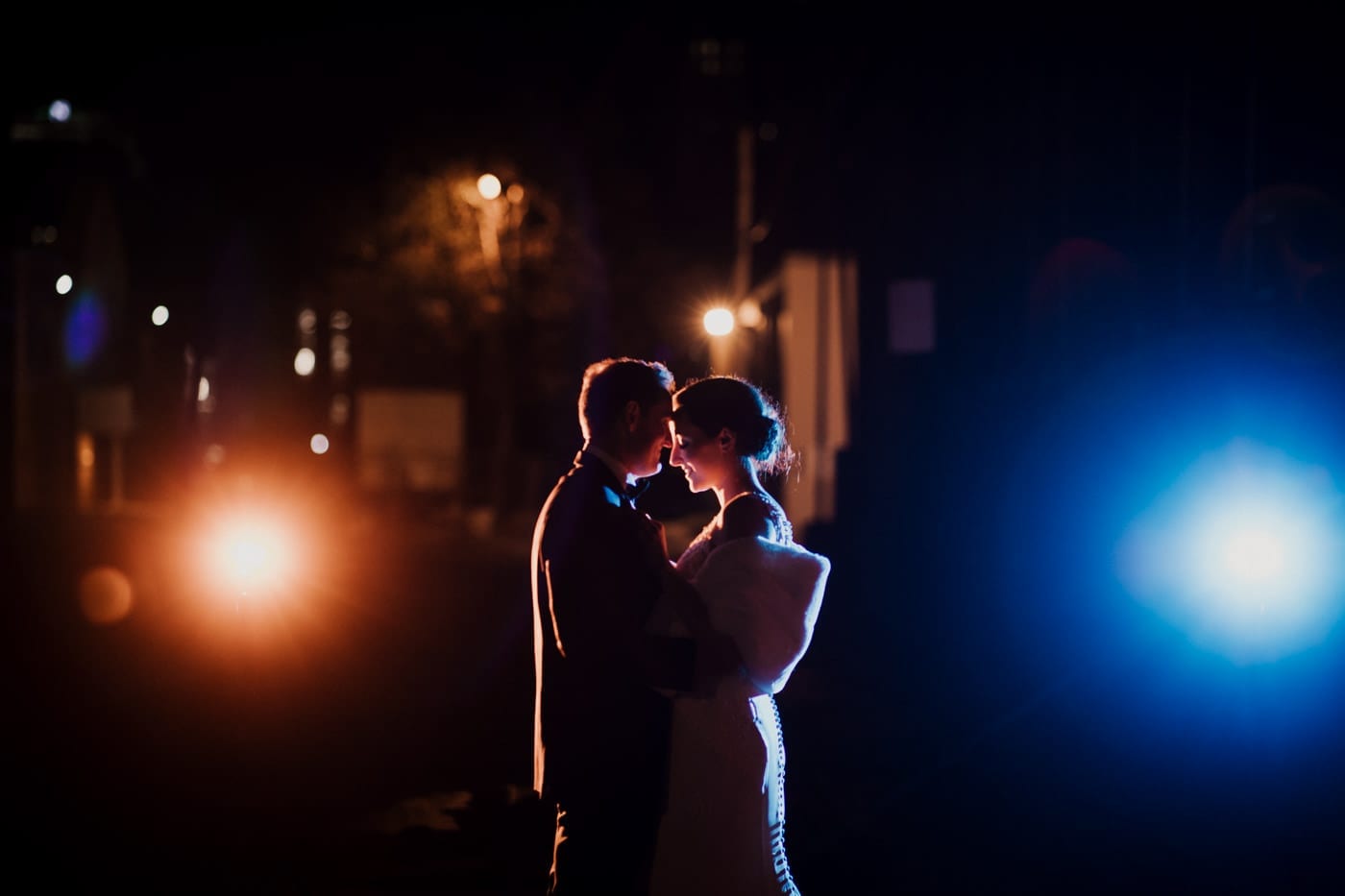bride and groom foreheads together at night at black tie winter wedding