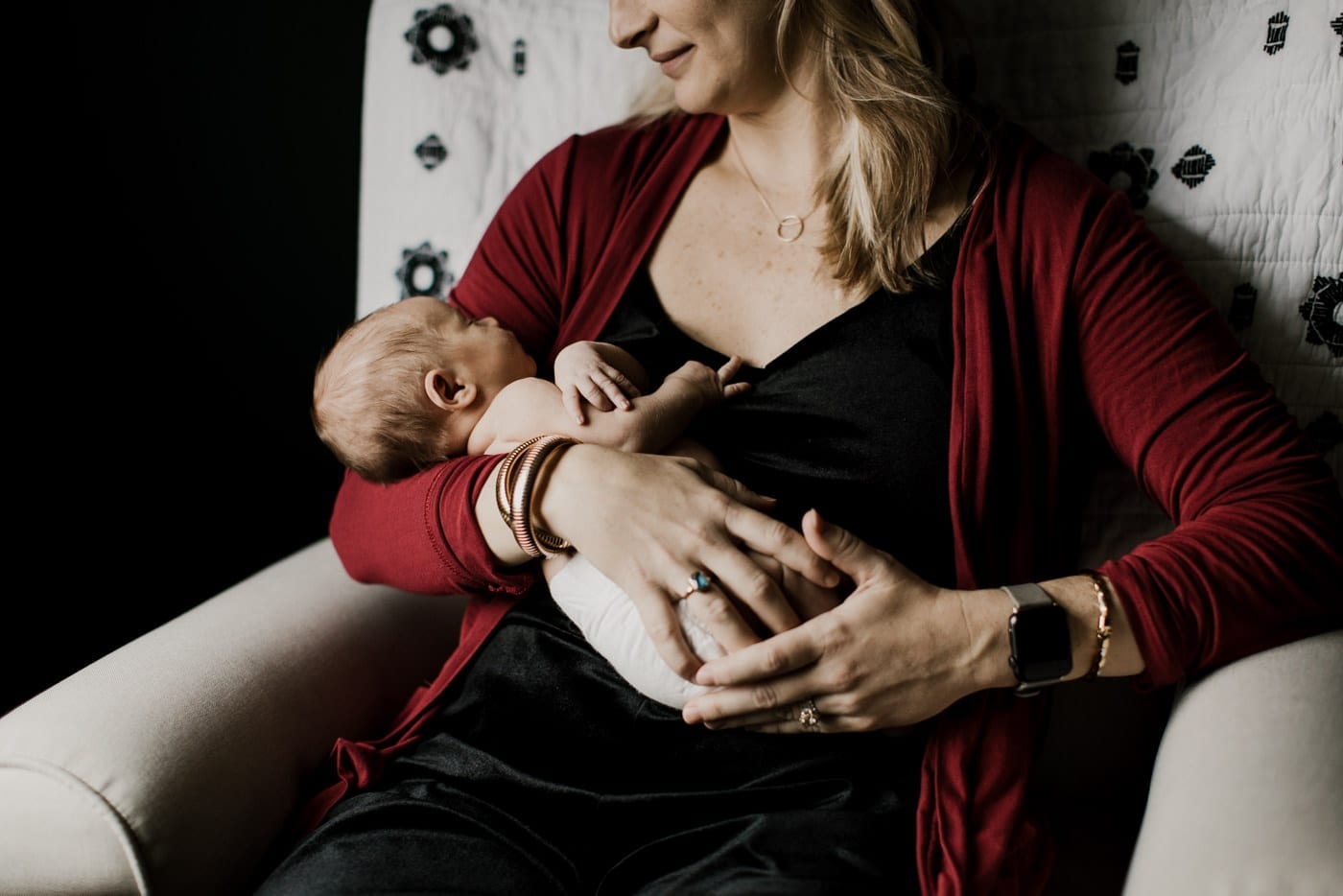 mom holding new born in rocker - in-home newborn session