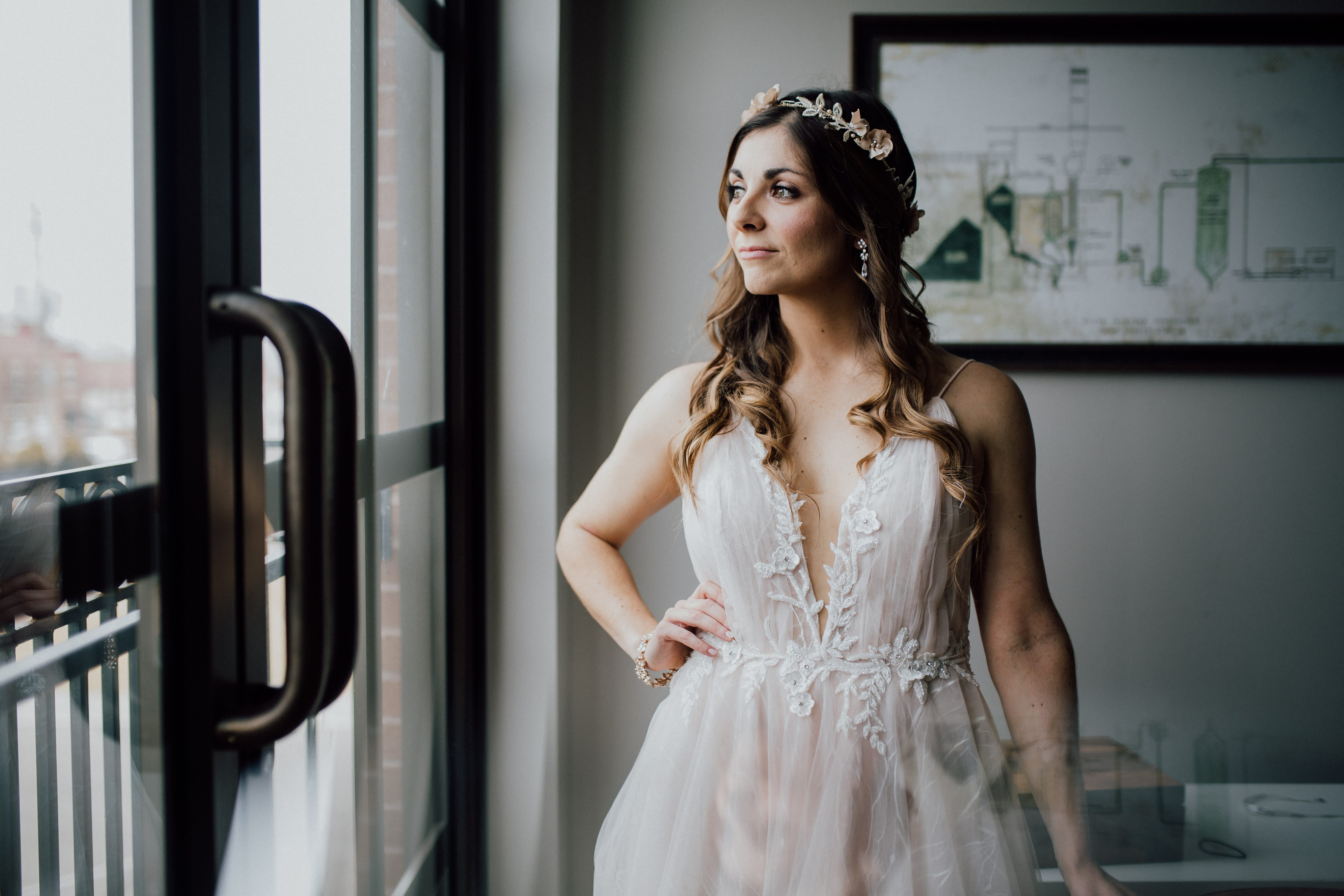Bride looks out the window and smiles reflected in the window at dayton ohio urban industrial wedding