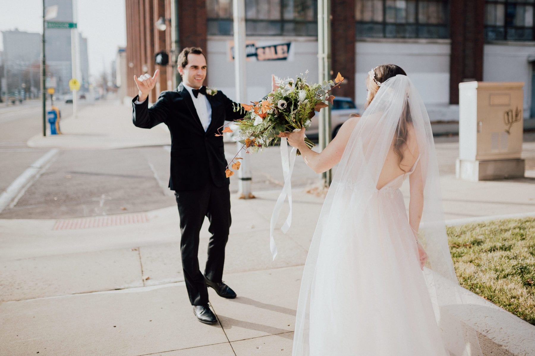 Bride and groom high five on street