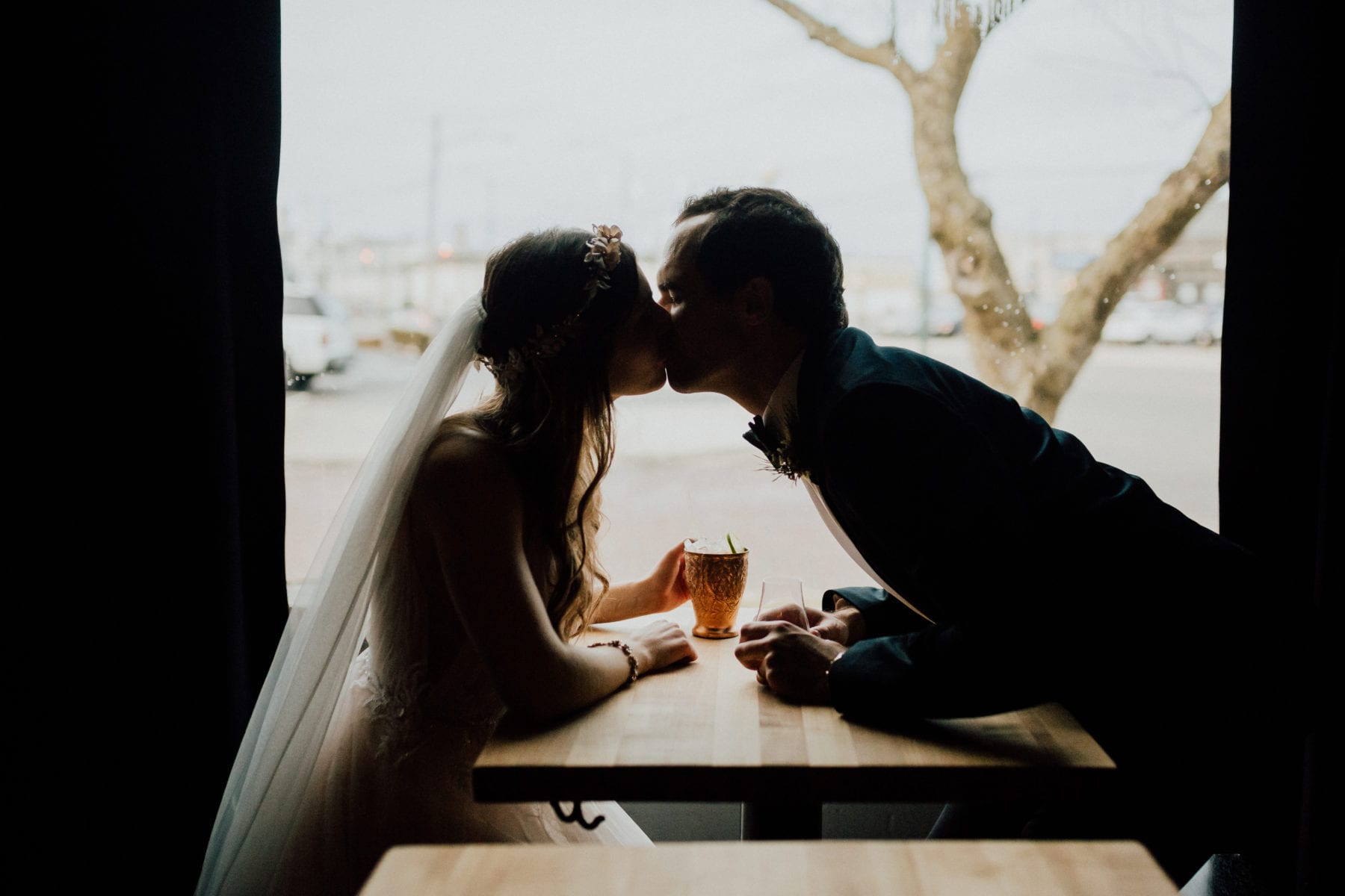 Bride and groom kiss at bar