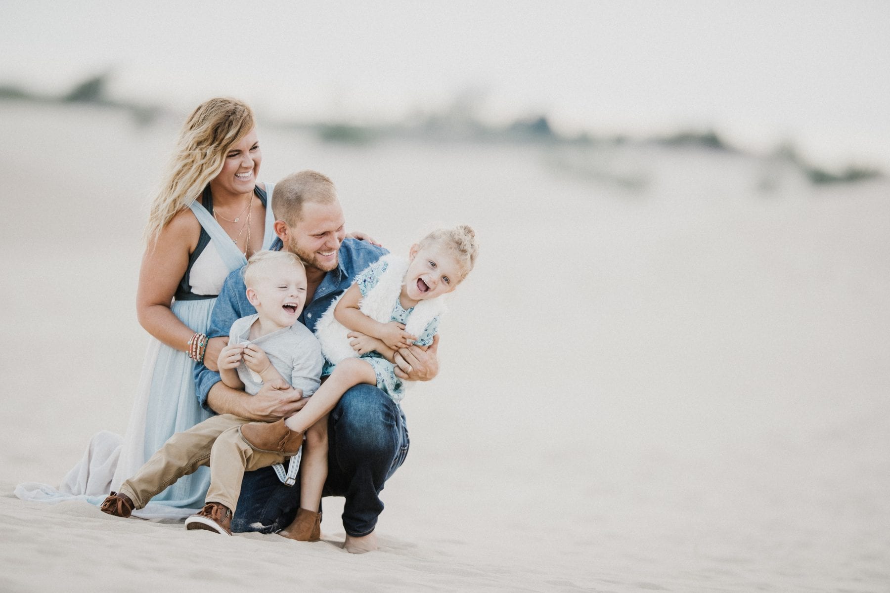 family laughs together at the sand dunes at Family Portrait Session Silver Lake Sand Dunes - Destination Photographer