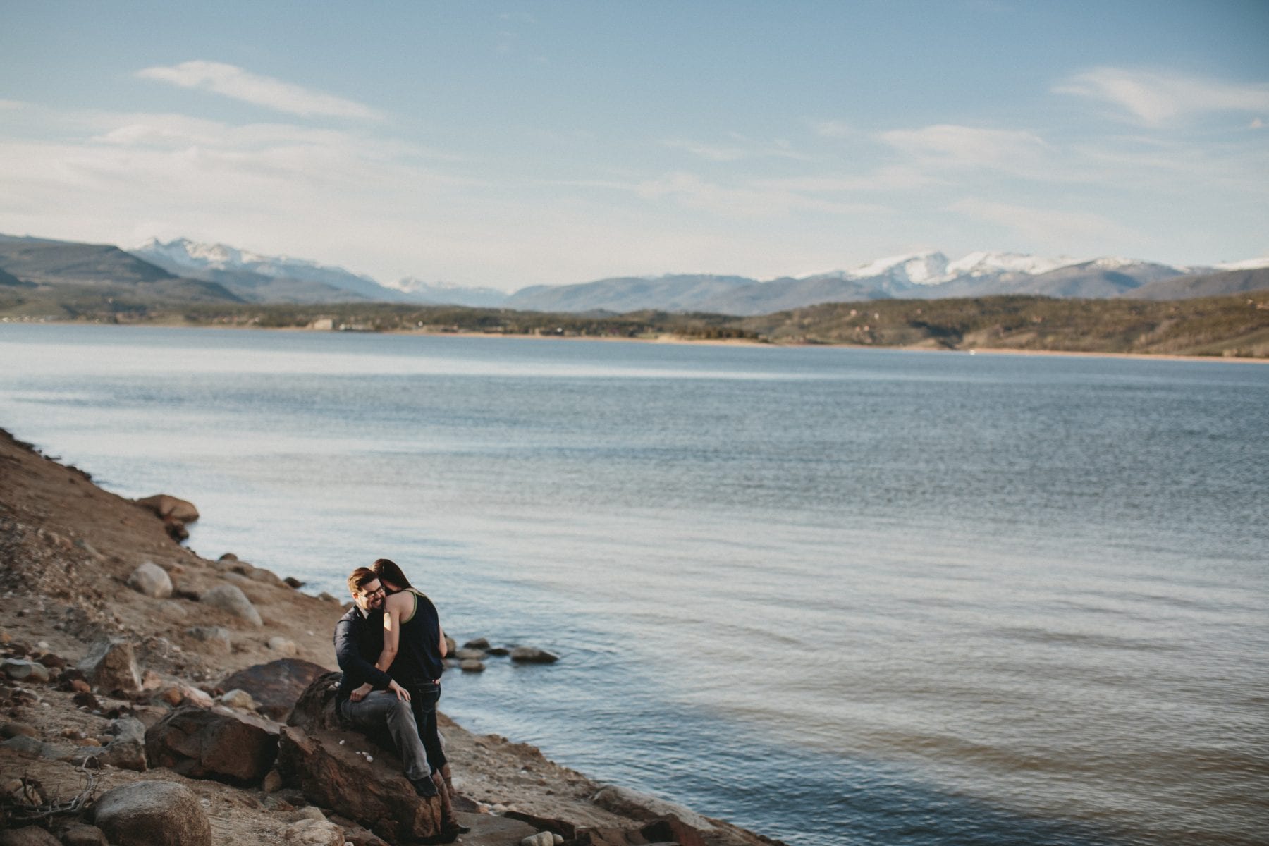 couple embraces by mountain lake at Grand Lake Colorado Family Portraits - Destination Photographer