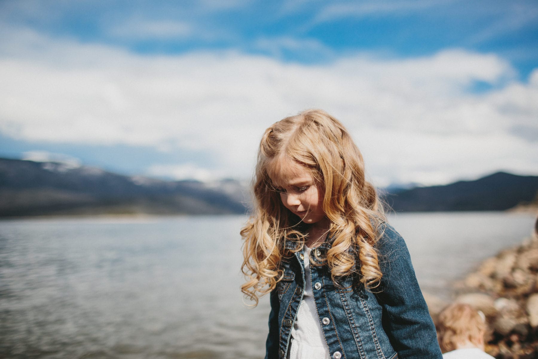 girl walks along lake shore at Grand Lake Colorado Family Portraits - Destination Photographer