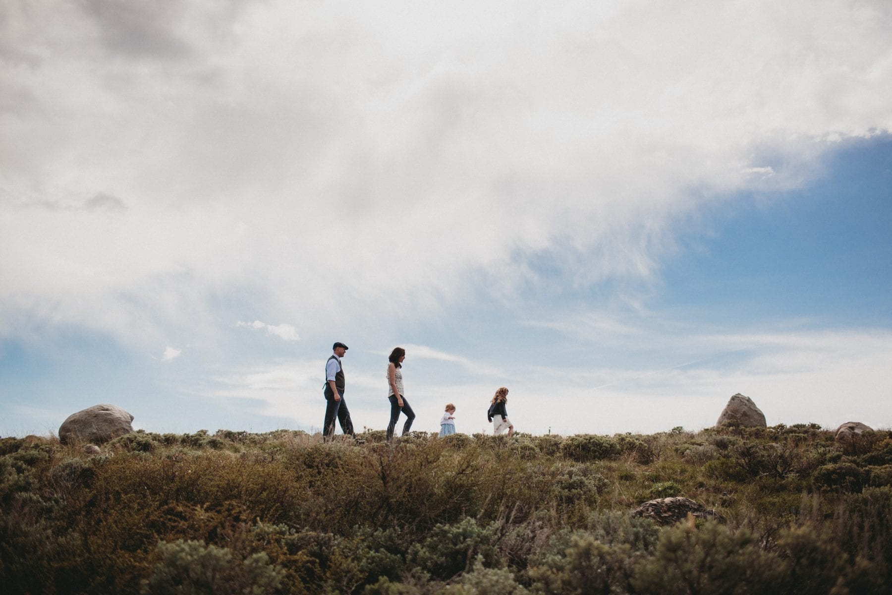 family walks in mountain field at Grand Lake Colorado Family Portraits - Destination Photographer