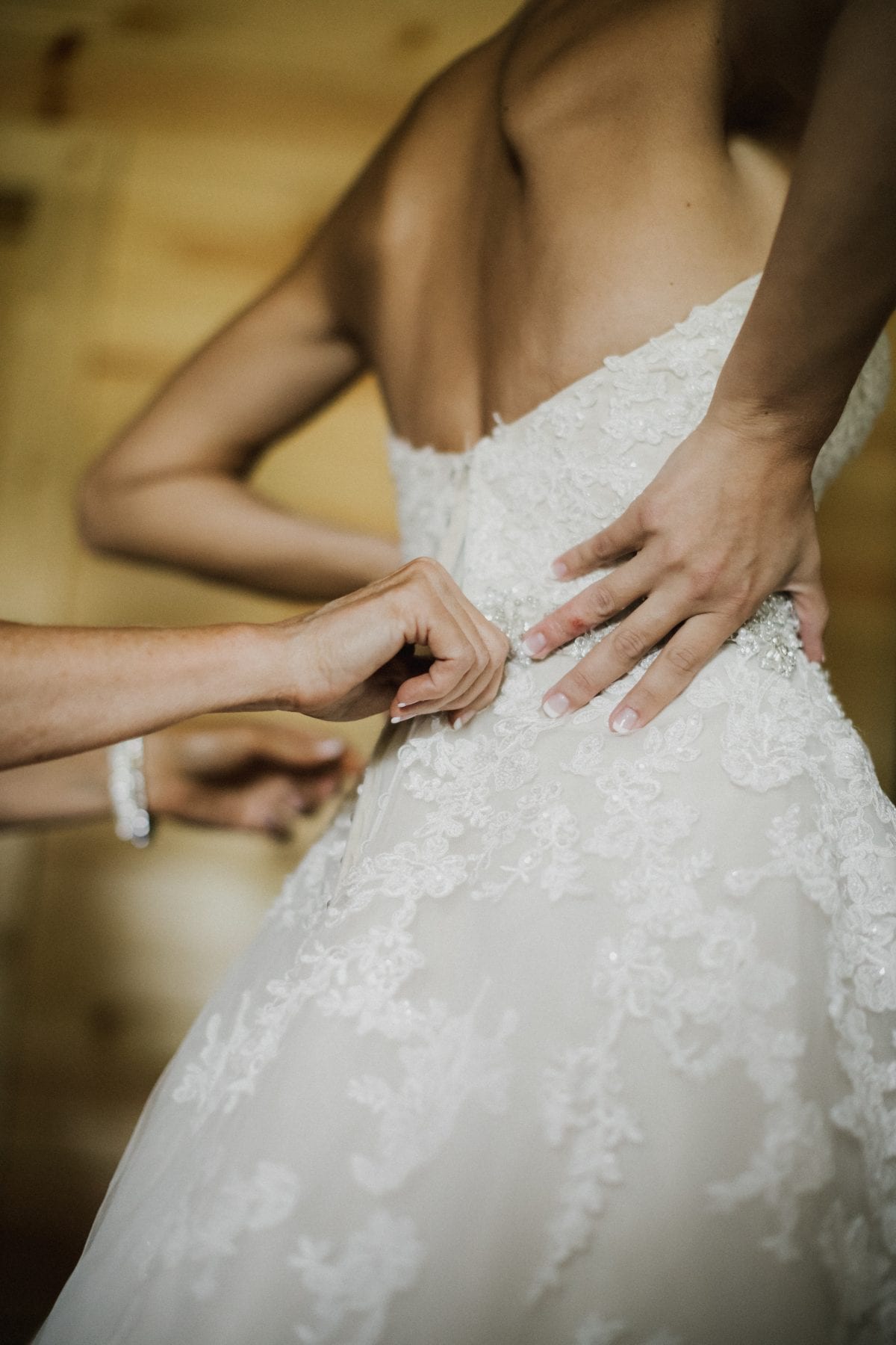 bride gets help putting on dress at Rolling Meadows Ranch Wedding - Cincinnati Wedding Photographer