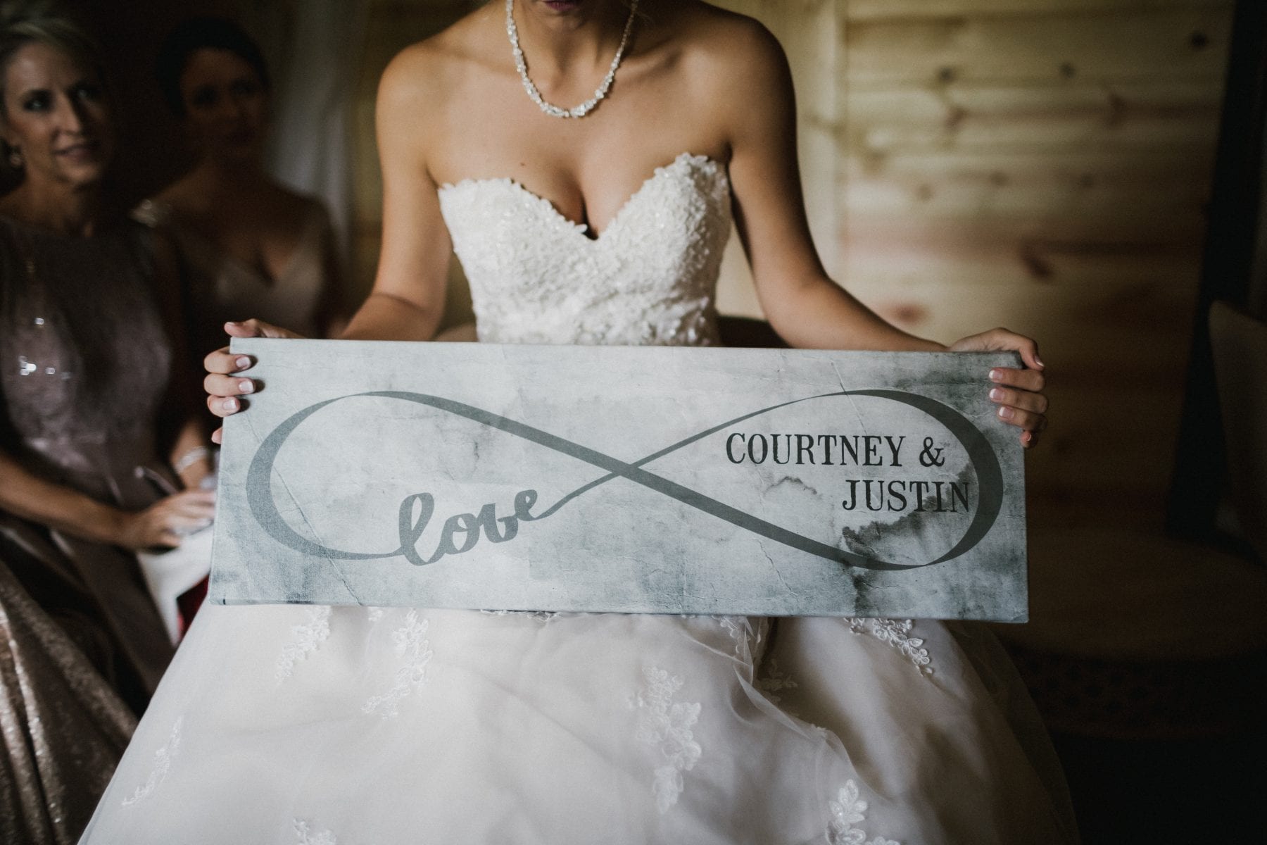 bride holds tin sign with wedding date