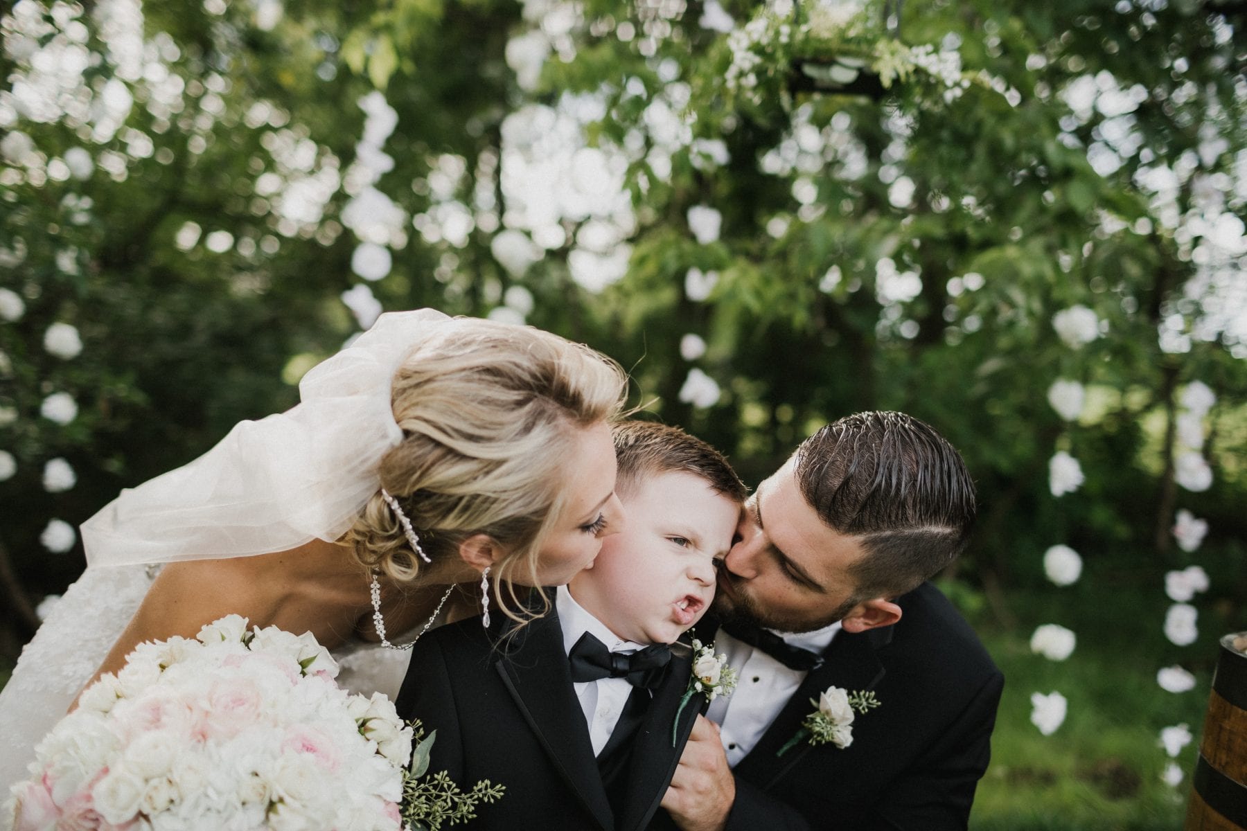 bride and groom kiss little boy on cheek at Rolling Meadows Ranch Wedding - Cincinnati Wedding Photographer