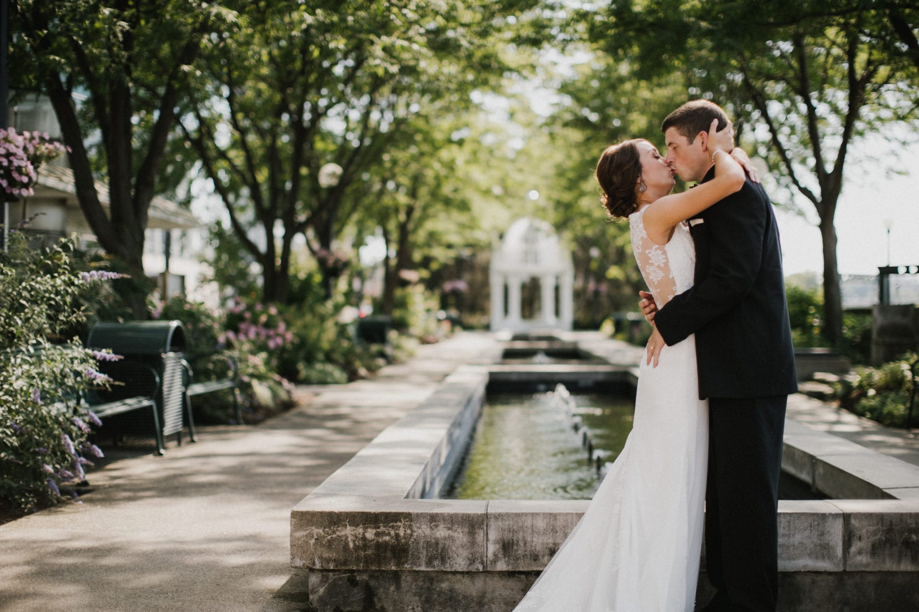 bride and groom kiss in front of fountain The Carrs Photography is an editorial wedding & portrait photography studio specializing in documenting fine weddings and storytelling portraits in Dayton Ohio, Chicago and Worldwide