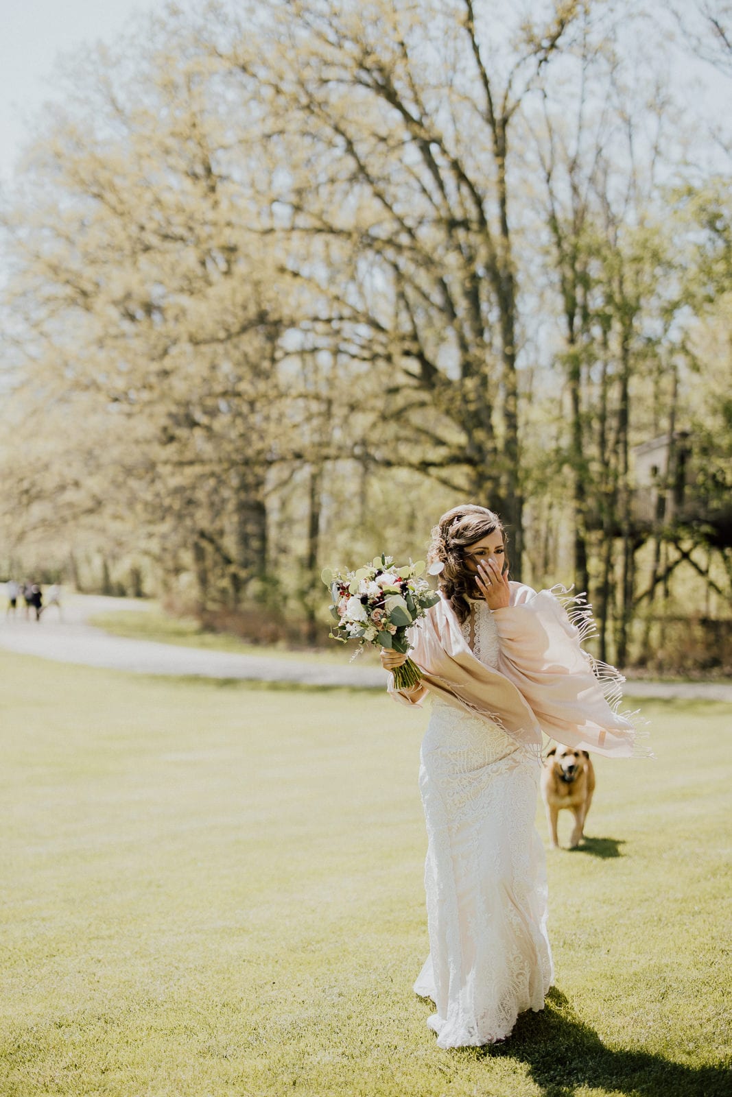 bride poses with shawl and flowers