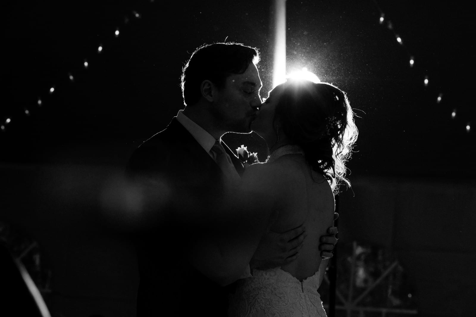 bride and groom kiss in silhouette