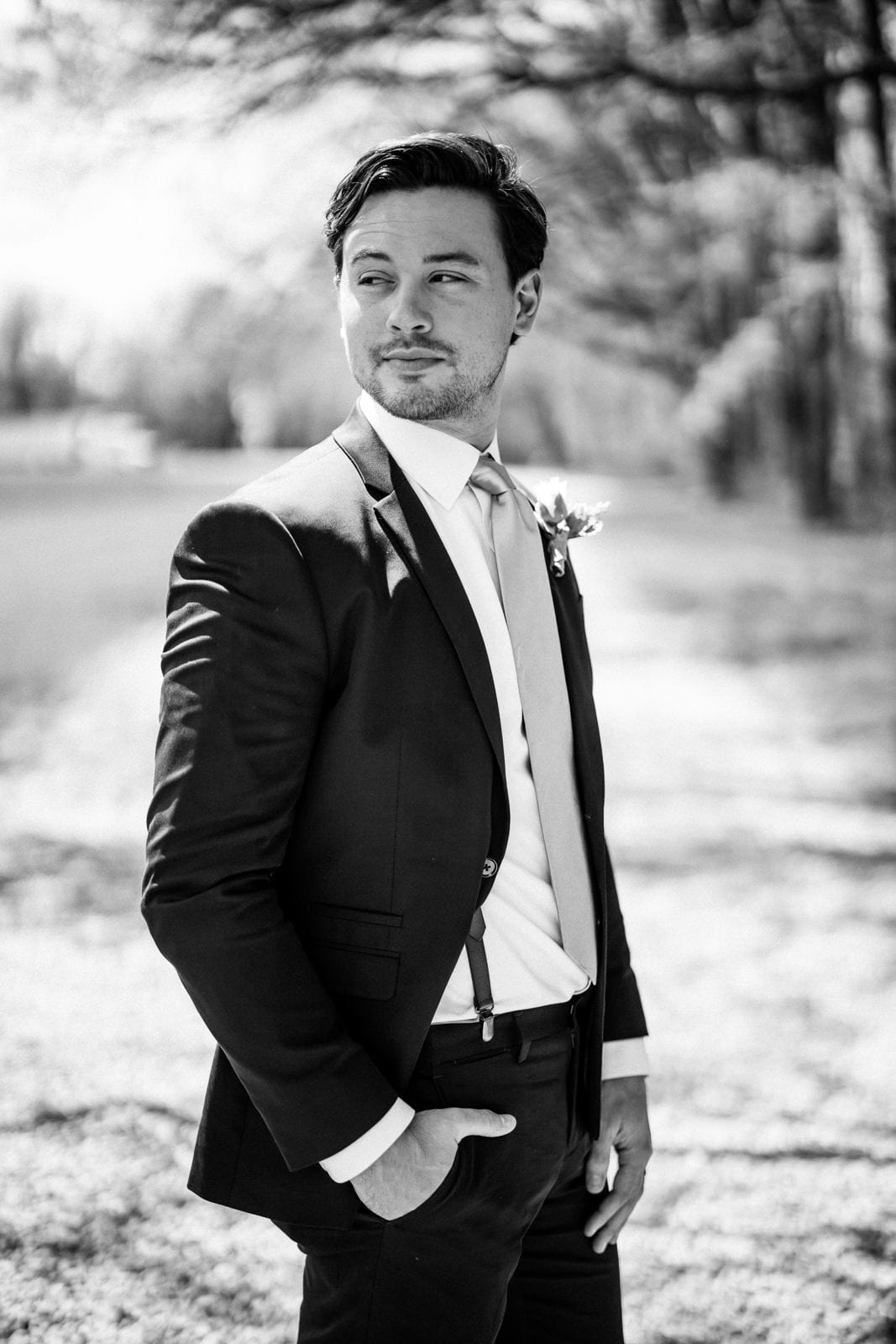Groom poses in black and white portrait