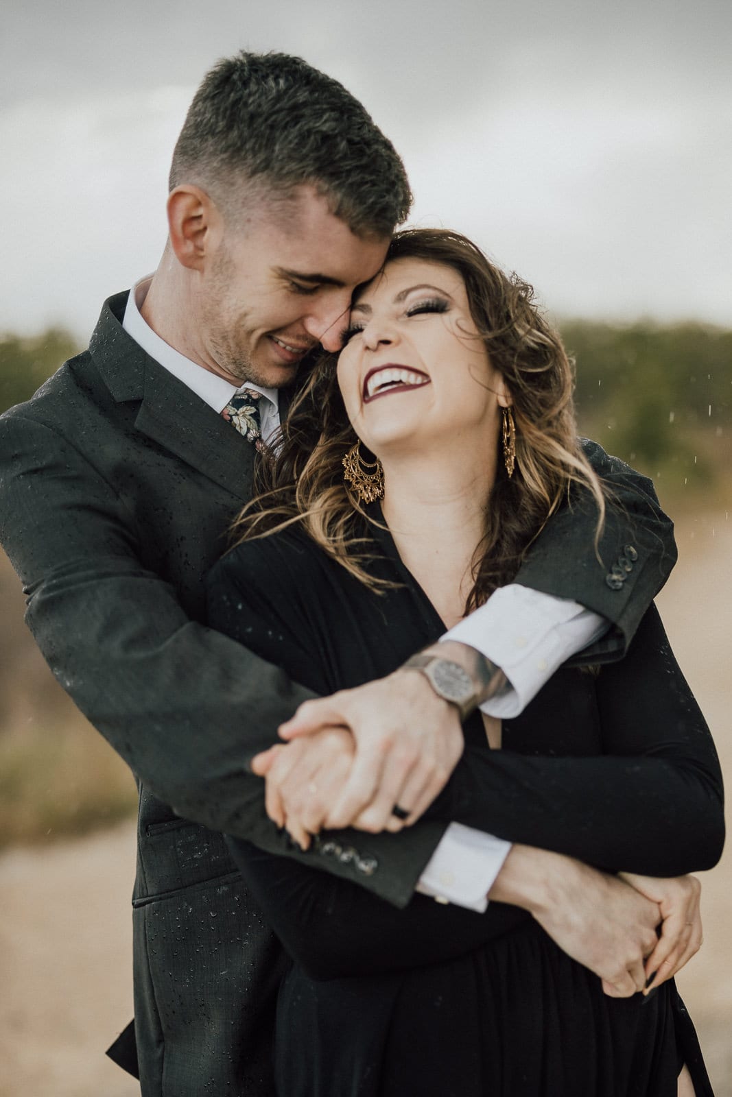 bride laughs as bride and groom embrace