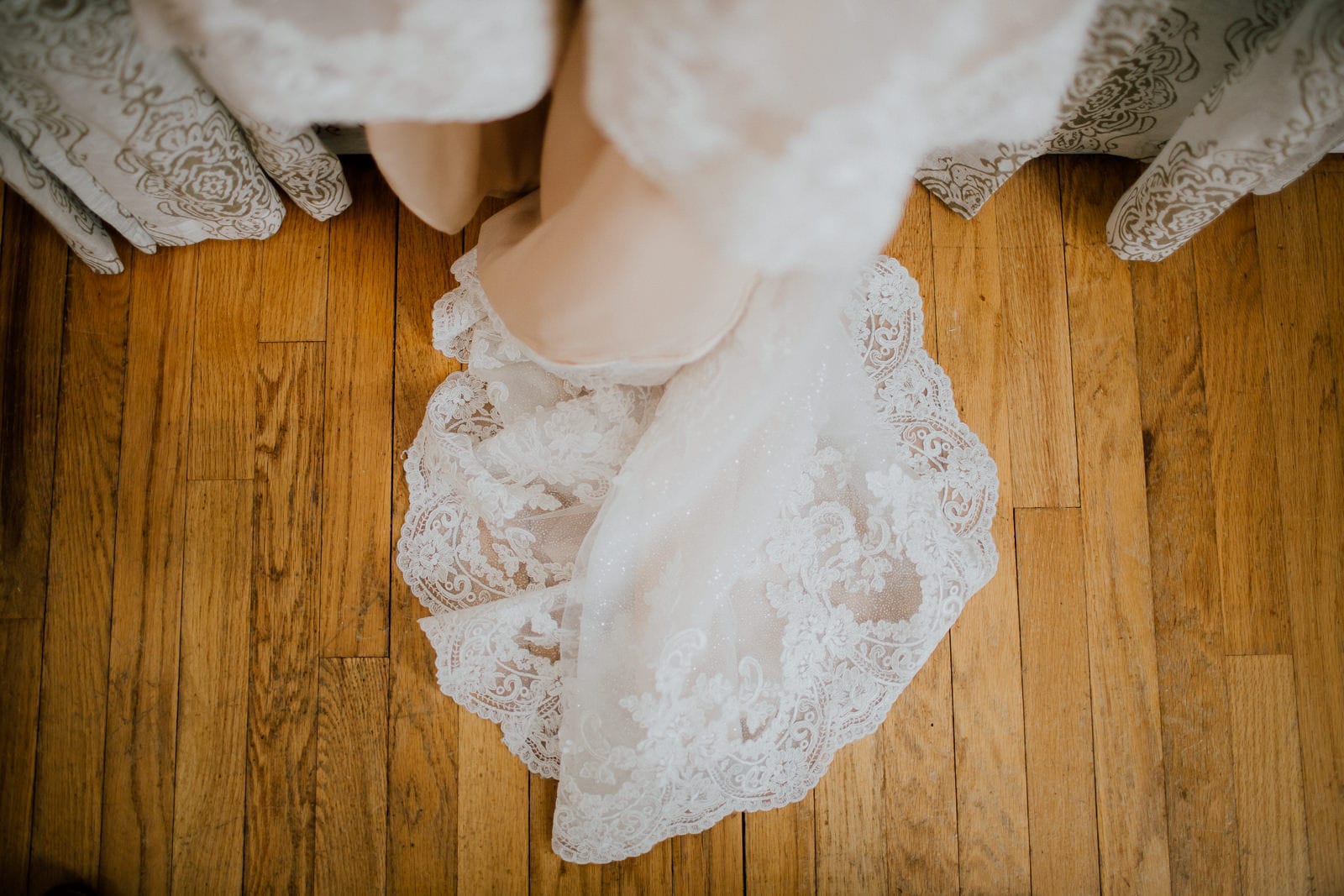 details of wedding dress pooled on floor
