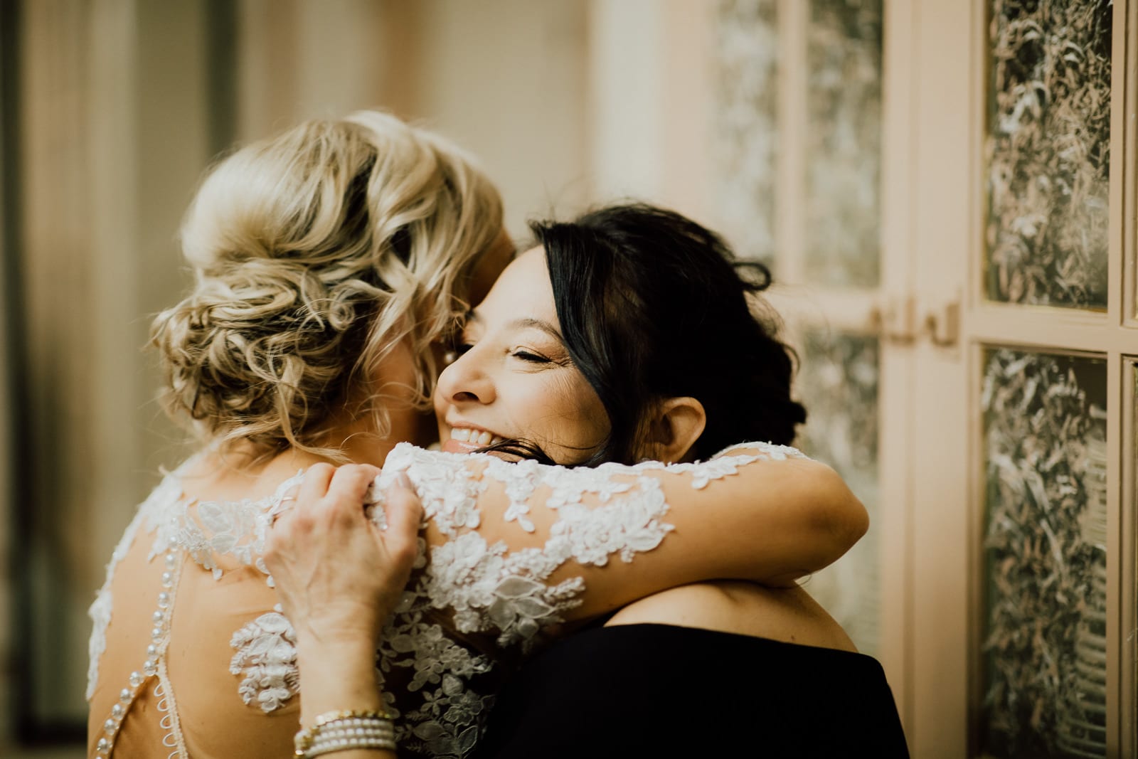 Bride and mother hug and cry