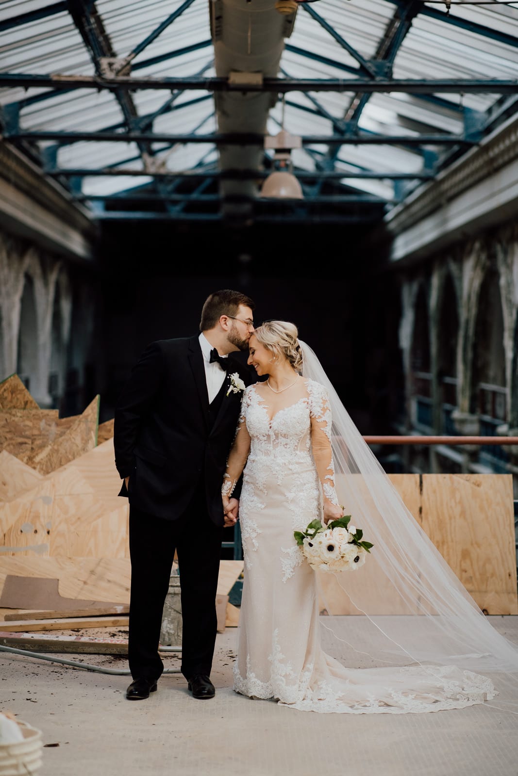 Bride and groom pose in urban construction project