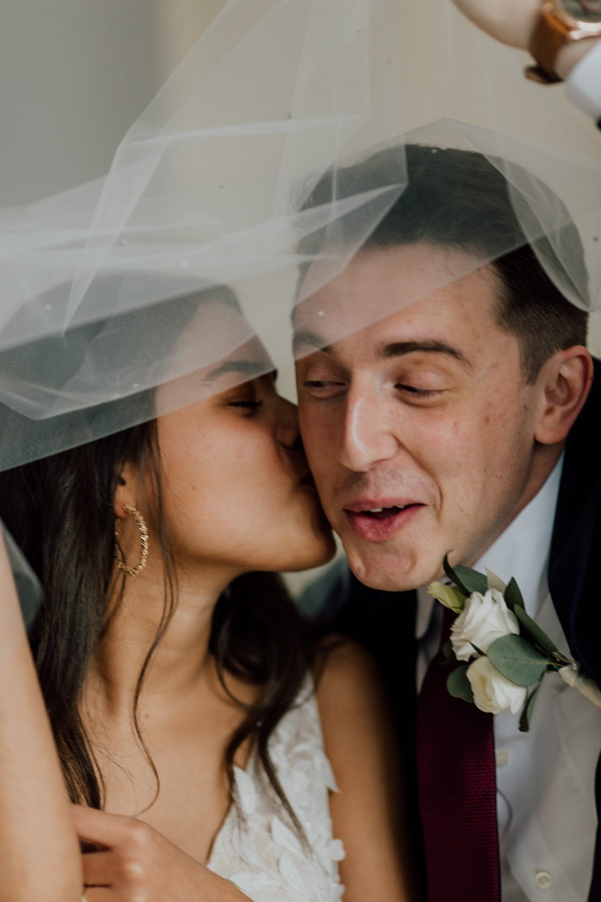 Bride kisses groom on cheek