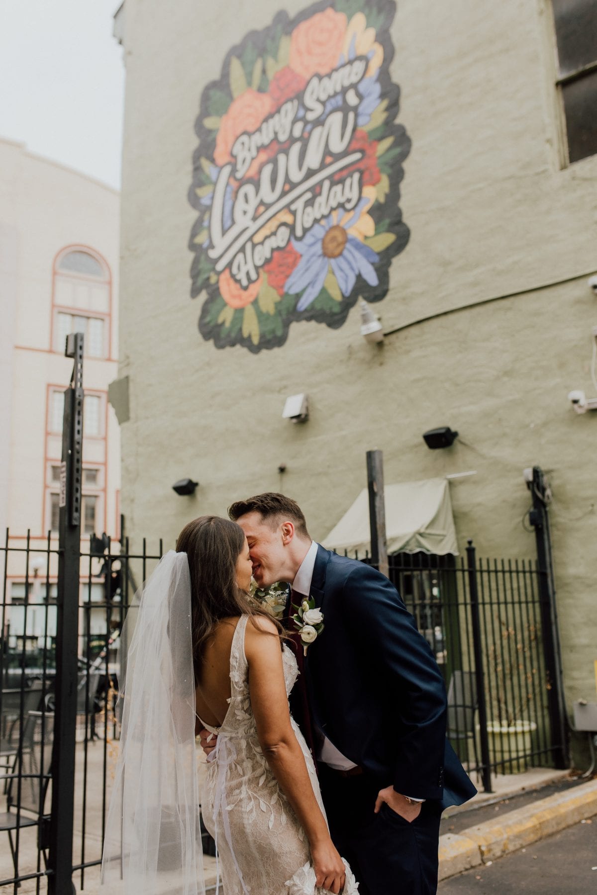 Bride and groom kiss in front of sign